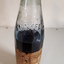 Glass bottle with ink and paper label "Made by the Blind"