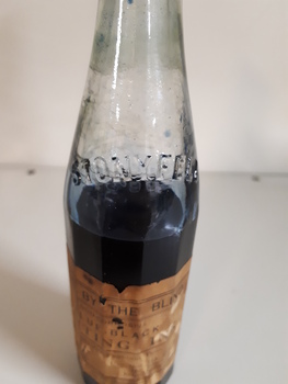 Glass bottle with ink and paper label "Made by the Blind"