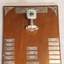 Wooden rectangle with metal plaques and image of lawn bowls in trophy topper that is wedged into board
