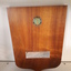 Wooden shield with enamel badge at top and metal plaque near base