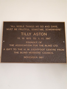 Brown metal plaque with gold writing