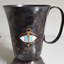 Tarnished silver mug with enamel badge