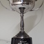 Front view of silver cup with two handles on black base