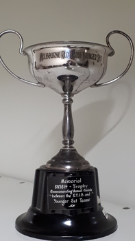Front view of silver cup with two handles on black base