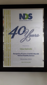 Silver board with blue writing and clear braille overlay