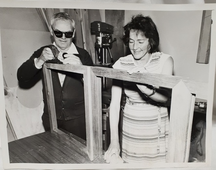 Two people working on a wooden frame