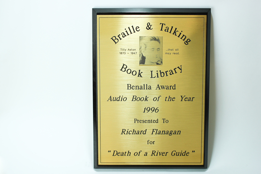 Wooden rectangle with metal plate inscribed with winners name