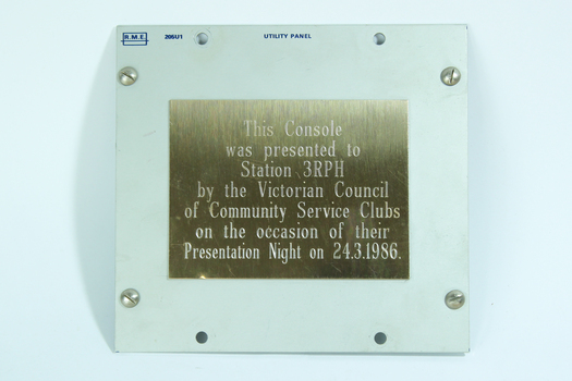 Gold coloured metal plate with inscription.