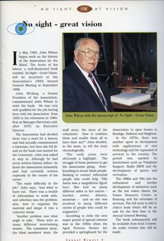 John Wilson seated at a desk with the manuscript for No Sight, Great Vision in front of him.