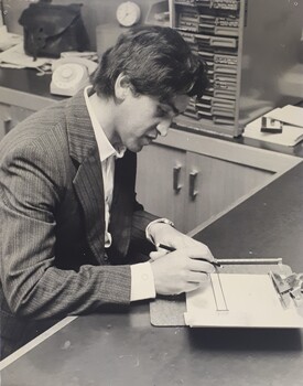 Male using template guide to write on a piece of paper