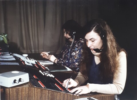 Woman on switchboard using a device to check extension numbers
