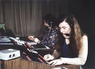 Woman on switchboard using a device to check extension numbers