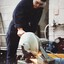 Young man using a bandsaw in a workshop 