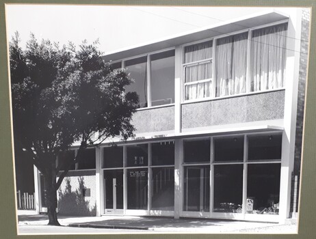 Front of two storey building with large glass windows
