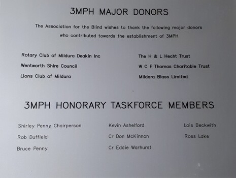 Silver plastic plaque with black writing