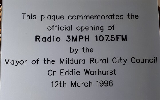 Silver plastic plaque with black writing