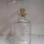 Glass bottle with cork stopper and glass measuring device attached above