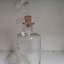 Glass bottle with cork stopper and glass measuring device attached above