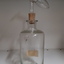 Glass bottle with cork stopper and glass measuring device attached above