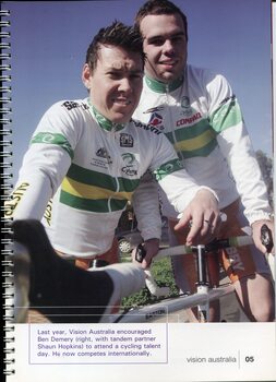 Two male tandem cyclists look towards camera