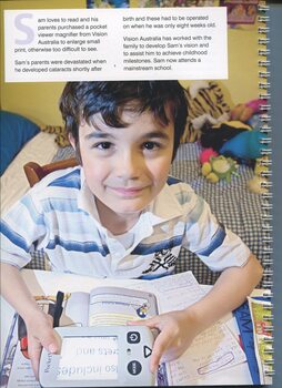 A young boy, Sam, holds a pocket magnifier over a book in his bedroom