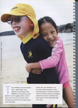 Mathew and Annabelle Zhou on the beach, wearing swimmers and a hat for Matthew