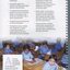 Seven schoolboys at wooden desks with a variety of objects in front of them