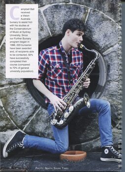Campbell Ball playing a saxophone against a concrete wall