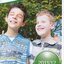 Two schoolboys, James and Riley, put an arm around each other's shoulders and turn towards camera