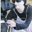 A young woman wearing black glasses and hat and her Seeing Eye Dog Warwick