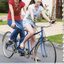 A mother, Karen, and daughter, Ebony, ride a tandem cycle on a suburban street