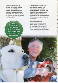 Older man playing a guitar, with his Seeing Eye Dog Nikki