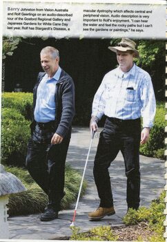 Two men, one with a white cane, walk along a path at the Gosford Regional Gallery and Japanese Gardens