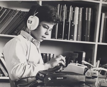 Young man types as he listens to a recording