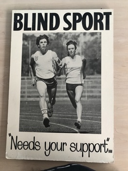 Two people running on athletic track holding a tether between them