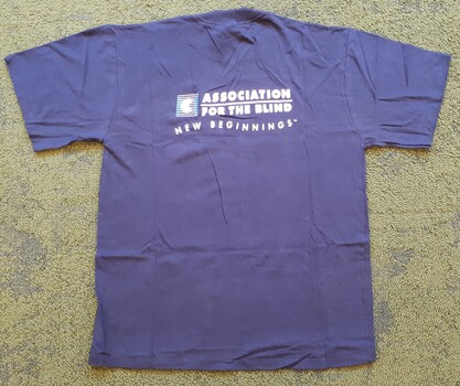 Royal blue tshirt with Association for the Blind - New Beginnings TM in white writing on back