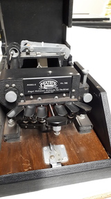 Six oval keys and one round key attached to embosser inside black vinyl case