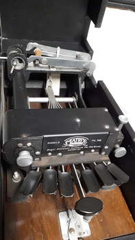Six oval keys and one round key attached to embosser inside black vinyl case