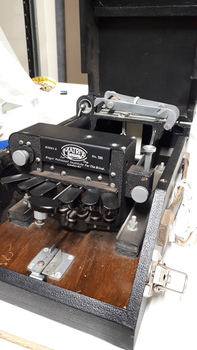 Six oval keys and one round key attached to embosser inside black vinyl case
