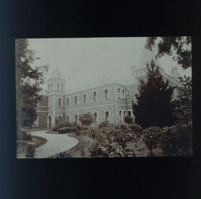 Two storey building and part of driveway viewed from side garden