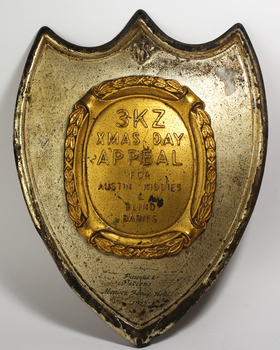 Tin shield with a centre piece coloured gold
