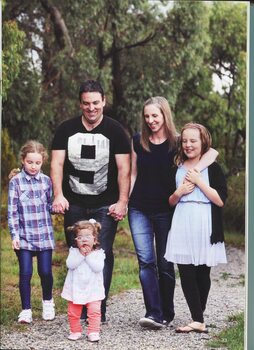 Image of family of five walking along a stone path in a wooded area