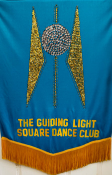 AFB Guiding Light logo in yellow and gold sequins on blue background