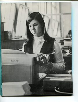 Young woman typing with headphones around her neck