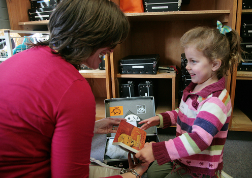 Roby showing Kate a book from the suitcase