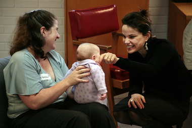 Sigrid Thornton touches the cheek of baby held by Sue Spenceley