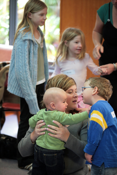 William speaking to his Mum who is holding a baby that is reaching for William