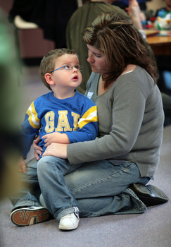 William sitting his in Mum's lap on the floor of the Feelix library