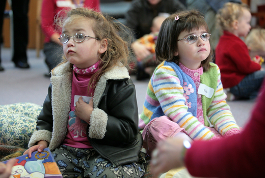 Amelia and Claudia wait for story time to begin on the mat at the Feelix library