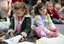 Amelia and Claudia wait for story time to begin on the mat at the Feelix library